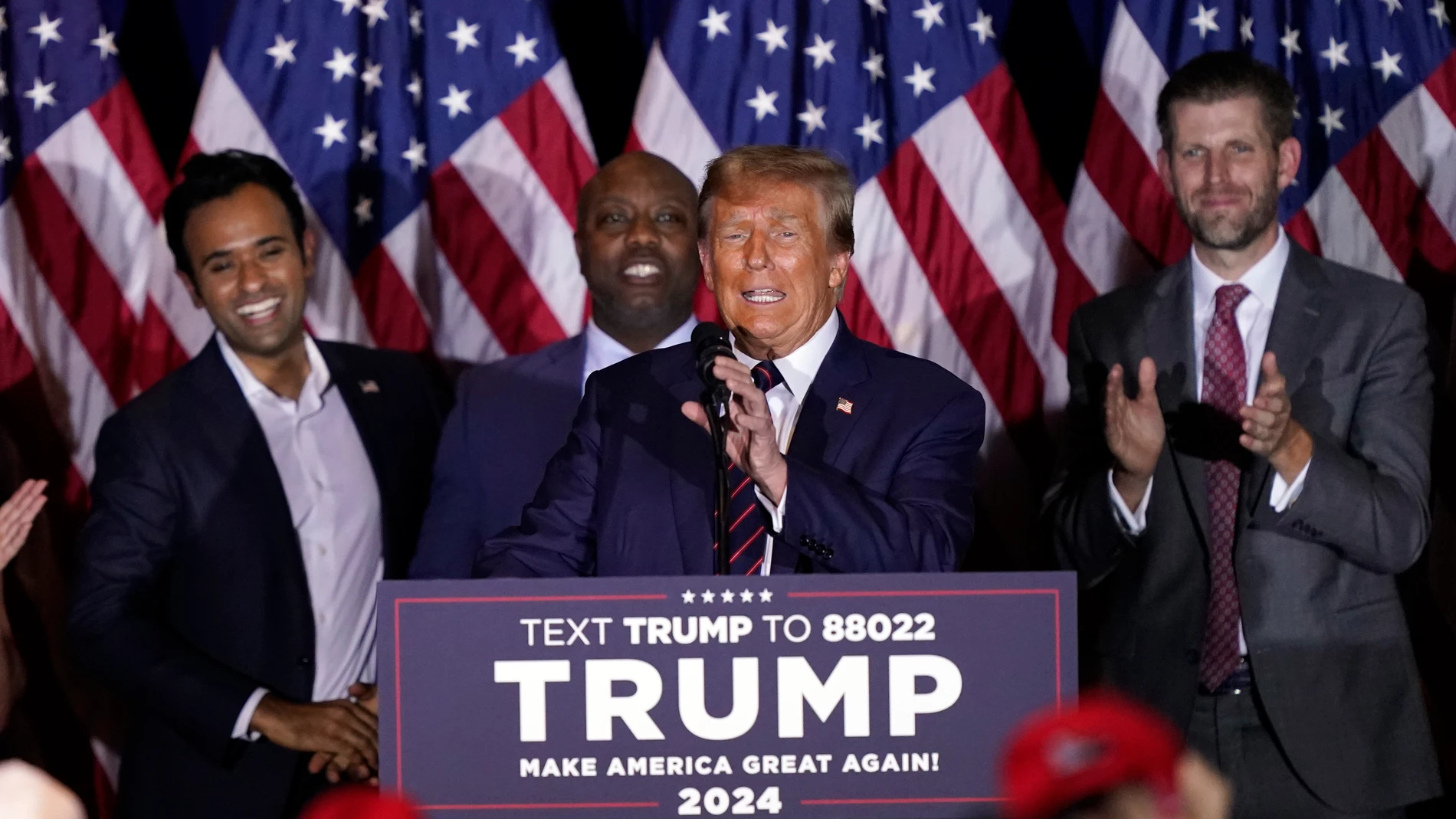 Republican presidential candidate former President Donald Trump speaks at a primary election night party in Nashua, N.H., Tuesday, Jan. 23, 2024, as Vivek Ramaswamy, Sen. Tim Scott, R-S.C., and Eric Trump laugh. (AP Photo/Pablo Martinez Monsivais)