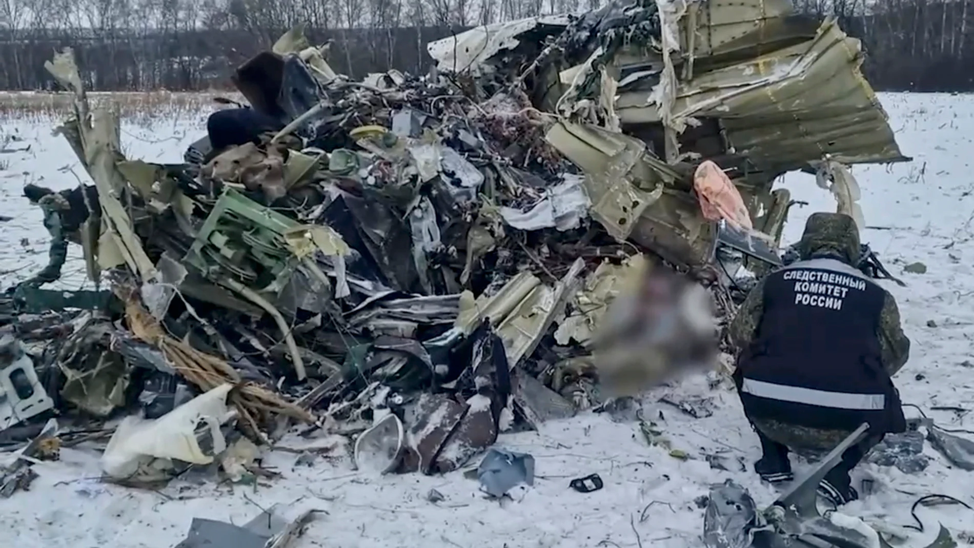 Yablonovo (Russian Federation), 25/01/2024.- A still image taken from handout video provided by the Russian Investigative Committee shows a Russian investigator examining debris at the crash site of an Ilyushin Il-76 airlifter near the village of Yablonovo, Belgorod region, Russia, 25 January 2024. A flight parameters recording device and a voice recorder were found at the site, the Committee confirmed. The Il-76 plane crashed on 24 January while transporting Ukrainian prisoners of war who we...