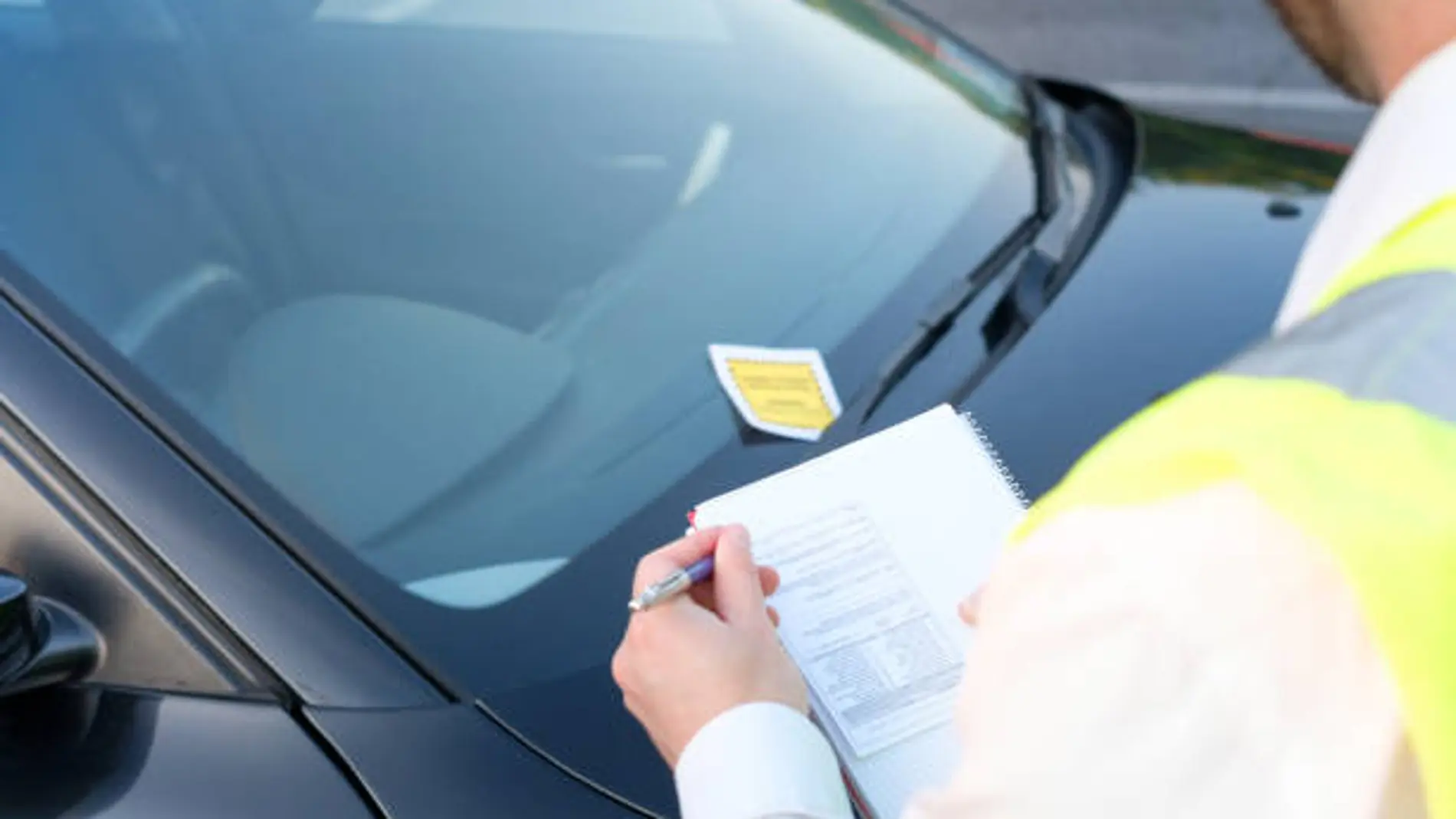 Un agente multando a un vehículo