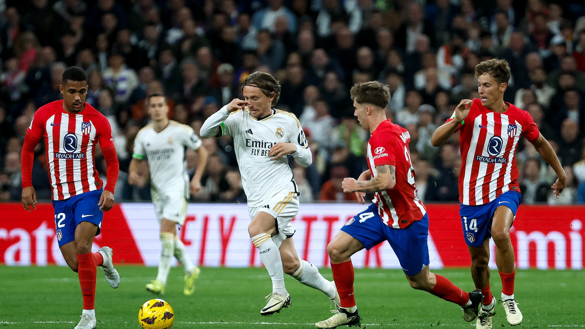 MADRID, 04/02/2024.- El centrocampista del Real Madrid Luka Modric (2-i) trata de escapar entre Marcos Llorente (d), Pablo Barrios (2-d) y Samuel Lino (i), del Atlético, durante el partido de LaLiga de fútbol que Real Madrid y Atlético de Madrid han disputado este domingo en el estadio Santigo Bernabéu. EFE/Juanjo Martín 