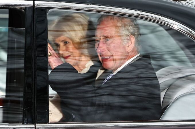 El rey Carlos III saluda a la multitud desde su coche oficial al abandonar Clarence House junto a la reina Camila
