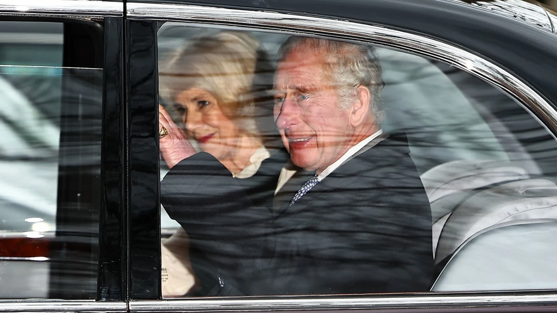 El rey Carlos III saluda a la multitud desde su coche oficial al abandonar Clarence House junto a la reina Camila