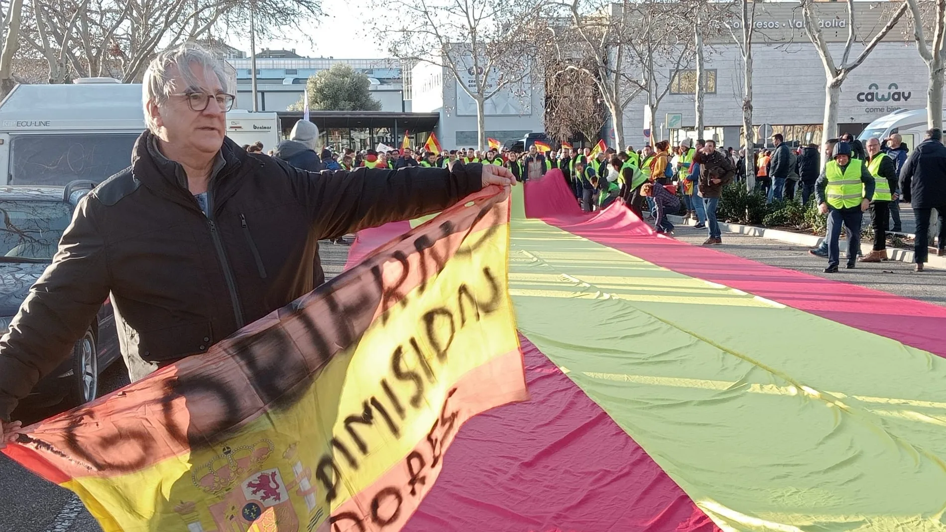 Un agricultor desplega una bandera de España junto a la Feria de Valladolid