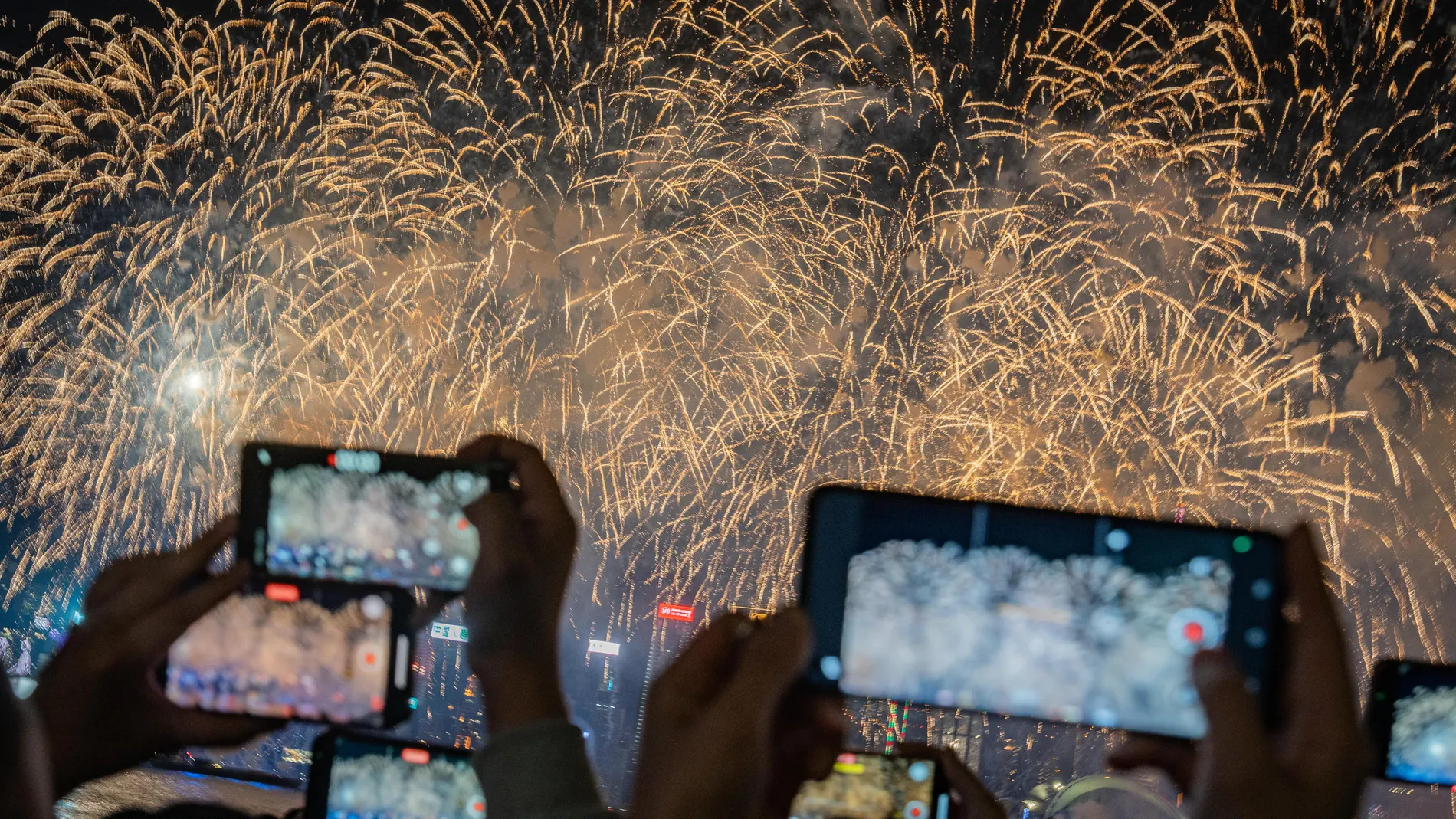 Hong Kong (China), 11/02/2024.- People take images of fireworks illuminating Victoria Harbour to celebrate the Chinese Lunar New Year in Hong Kong, China, 11 February 2024. EFE/EPA/LEUNG MAN HEI 