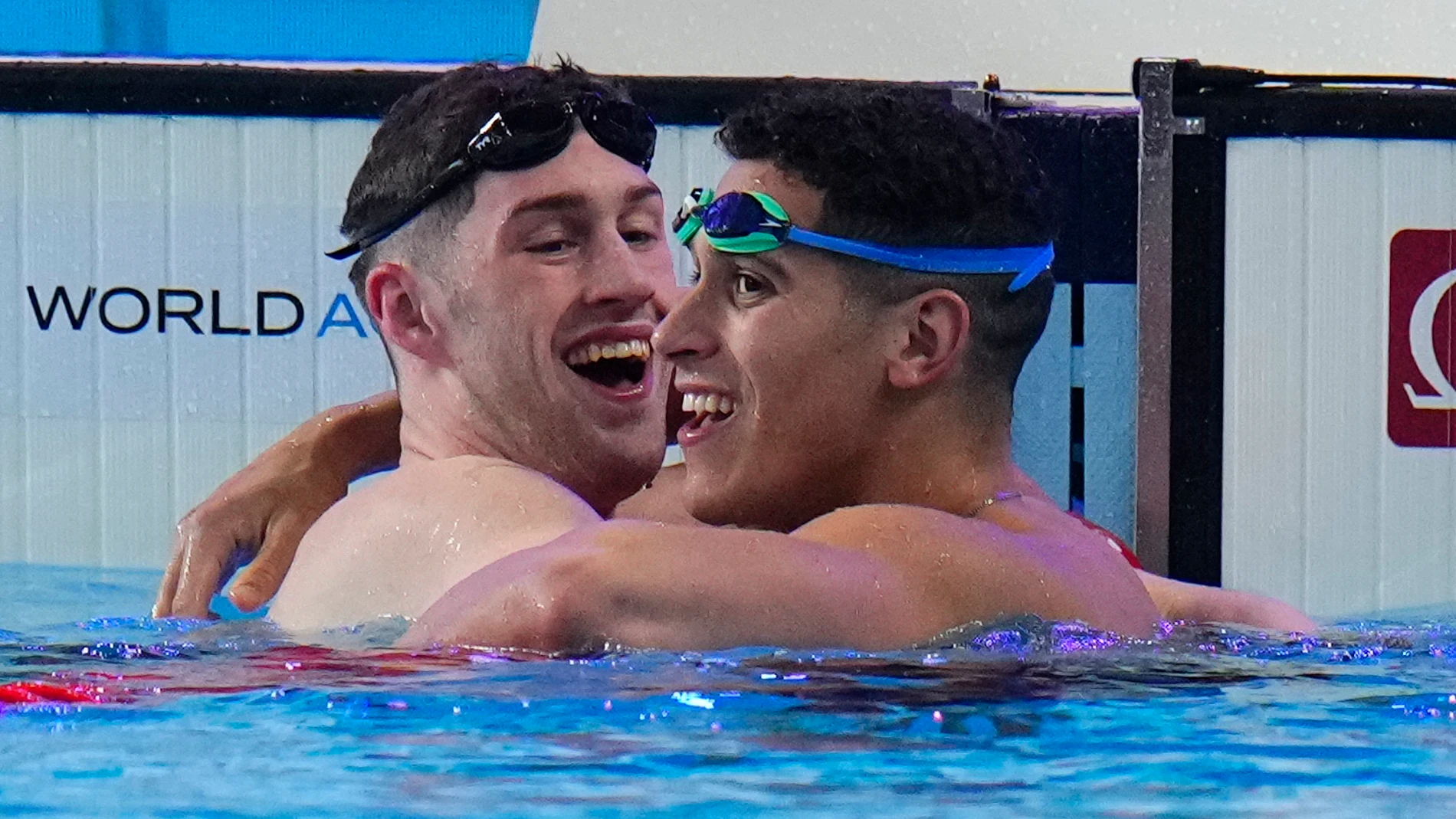 Hunter Armstrong of the United States, left, gold medal celebrates with Hugo Gonzalez of Spain, silver medal after the men's 100-meter backstroke final at the World Aquatics Championships in Doha, Qatar, Tuesday, Feb. 13, 2024. (AP Photo/Hassan Ammar)