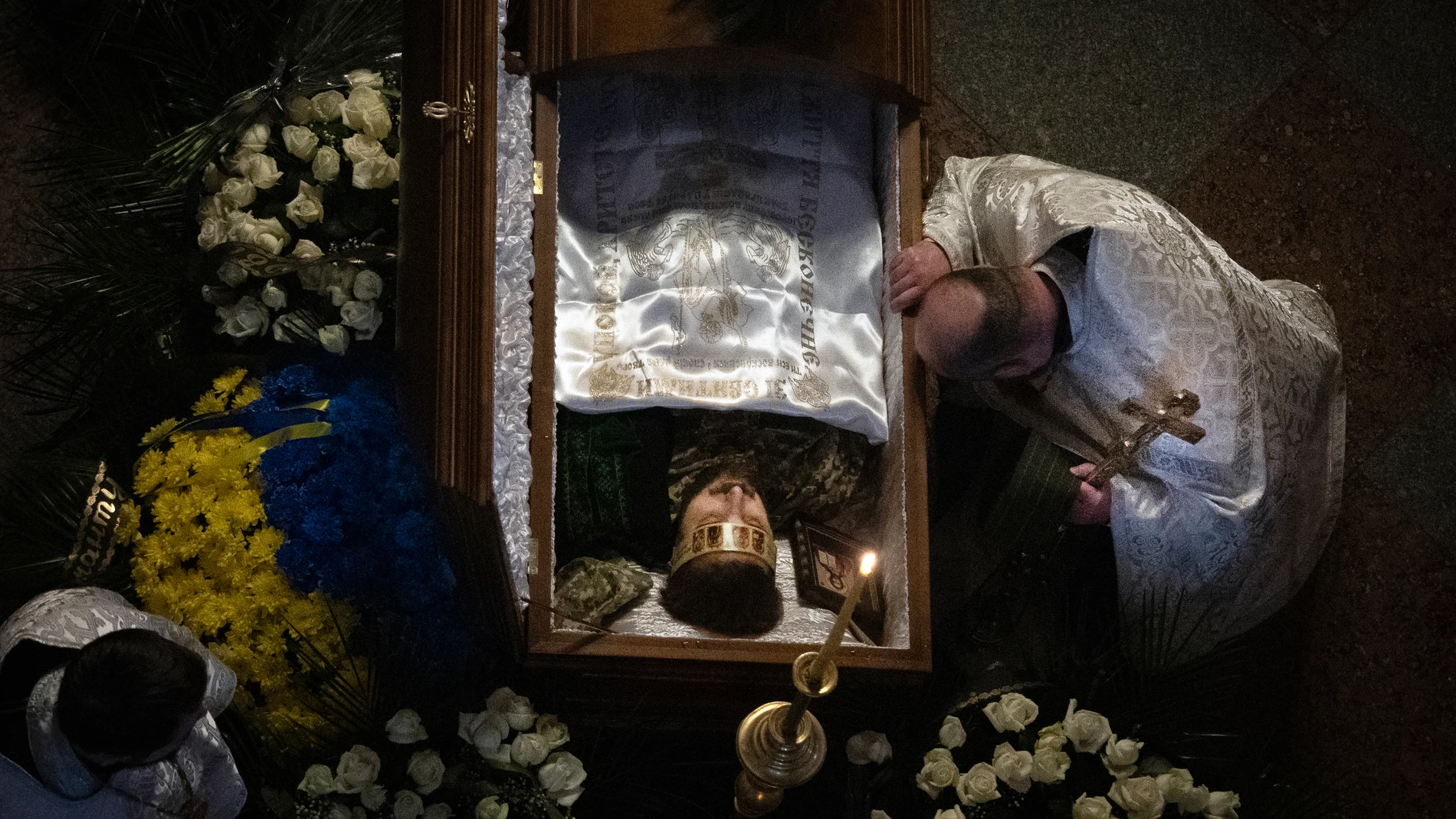 A priest pays his respects during the funeral of Ukrainian serviceman and famous poet Maksym Kryvtsov in St. Michael Cathedral in Kyiv, Ukraine, Thursday, Jan. 11, 2024. (AP Photo/Efrem Lukatsky)
