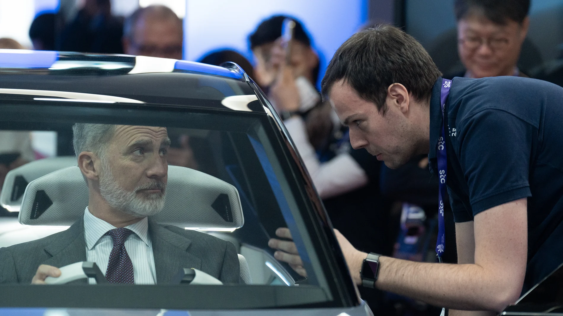 El Rey Felipe VI (i) probando un coche en el Mobile World Congress (MWC) para encabezar la inauguración del evento, en el recinto Gran Via de Fira de Barcelona en L'Hospitalet de Llobregat, a 26 de febrero de 2024, en Barcelona, Catalunya (España).