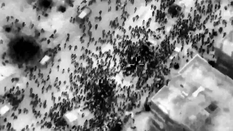 This image grab from a handout video released by the Israeli army on February 29, 2024, shows what the army says are Gazans around aid trucks in Gaza City. - Israeli forces shot dead 104 people when a crowd rushed towards aid trucks on February 29, the health ministry in Hamas-run Gaza said. Israeli sources confirmed that troops opened fire at Palestinians rushing toward aid trucks in Gaza, with one saying soldiers thought they "posed a threat" to troops. (Photo by Aline MANOUKIAN / Israeli Army / AFP) / === RESTRICTED TO EDITORIAL USE - MANDATORY CREDIT "AFP PHOTO / HANDOUT / ISRAELI ARMY' - NO MARKETING NO ADVERTISING CAMPAIGNS - DISTRIBUTED AS A SERVICE TO CLIENTS == - === RESTRICTED TO EDITORIAL USE - MANDATORY CREDIT "AFP PHOTO / Handout / Israeli Army' - NO MARKETING NO ADVERTISING CAMPAIGNS - DISTRIBUTED AS A SERVICE TO CLIENTS == /