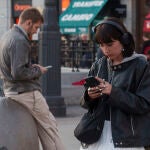 Una persona mira su movil en la Puerta del Sol. 