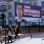 Gente pasa en Lisboa junto a un cartel de Andre Ventura, el líder de la extrema derecha portuguesa