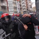 Un ertzaintza y otro individuo en los disturbios del pasado 3 de marzo en Vitoria