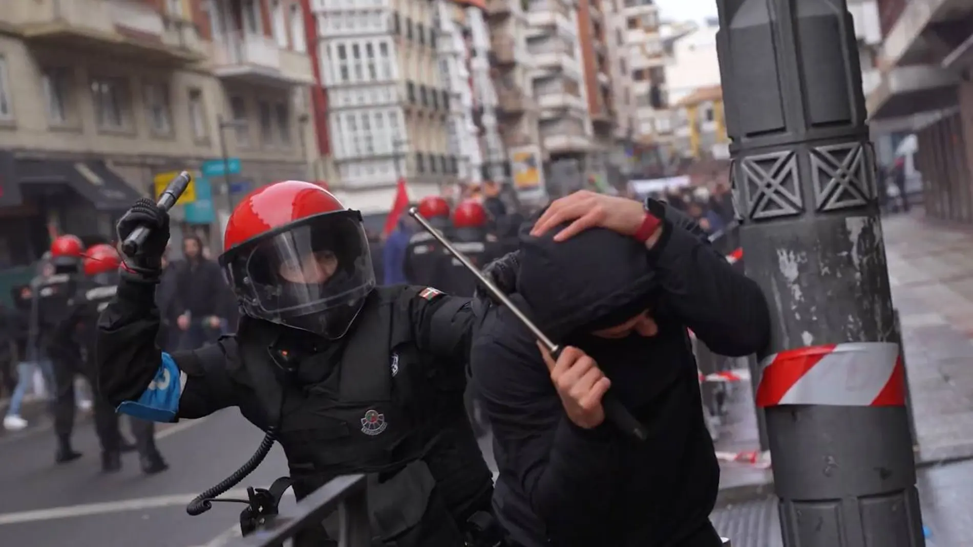 Un ertzaintza y otro individuo en los disturbios del pasado 3 de marzo en Vitoria