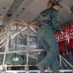 Una militar del Ejército del Aire asegura el paquete en el interior del avión que despegó hacia Jordania
