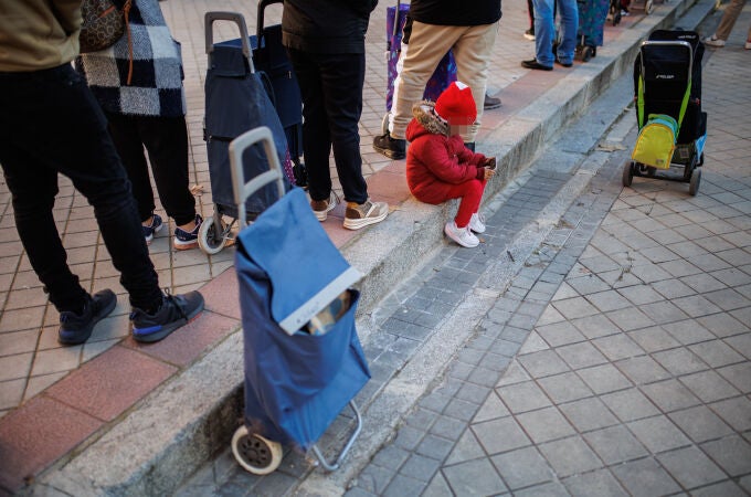 Colas de gente durante la entrega regalos a más100 niños vulnerables, en Madrid (España). Colas del hambre