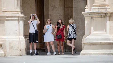 Varios visitantes pasean por el centro de Sevilla, la primera ciudad andaluza que regulará los apartamentos turísticos
