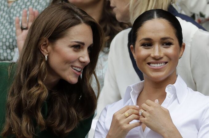 Britain's Kate, Duchess of Cambridge, left, and Meghan, Duchess of Sussex speak as they sit in the Royal Box on Centre Court