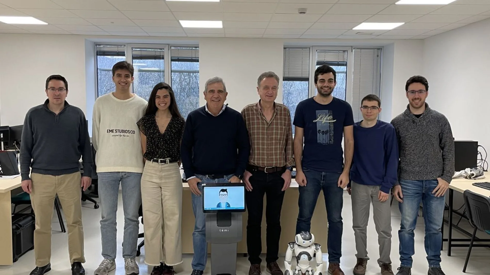 Miembros del equipo de investigación del proyecto EIRAB dirigido por el profesor Eduardo Zalama. Delante uno de los 15 robots que se desplegará en 60 domicilios de Castilla y León, junto a otro de los prototipos que están analizando.