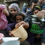 Internally displaced Palestinians gather to collect food aid in Rafah