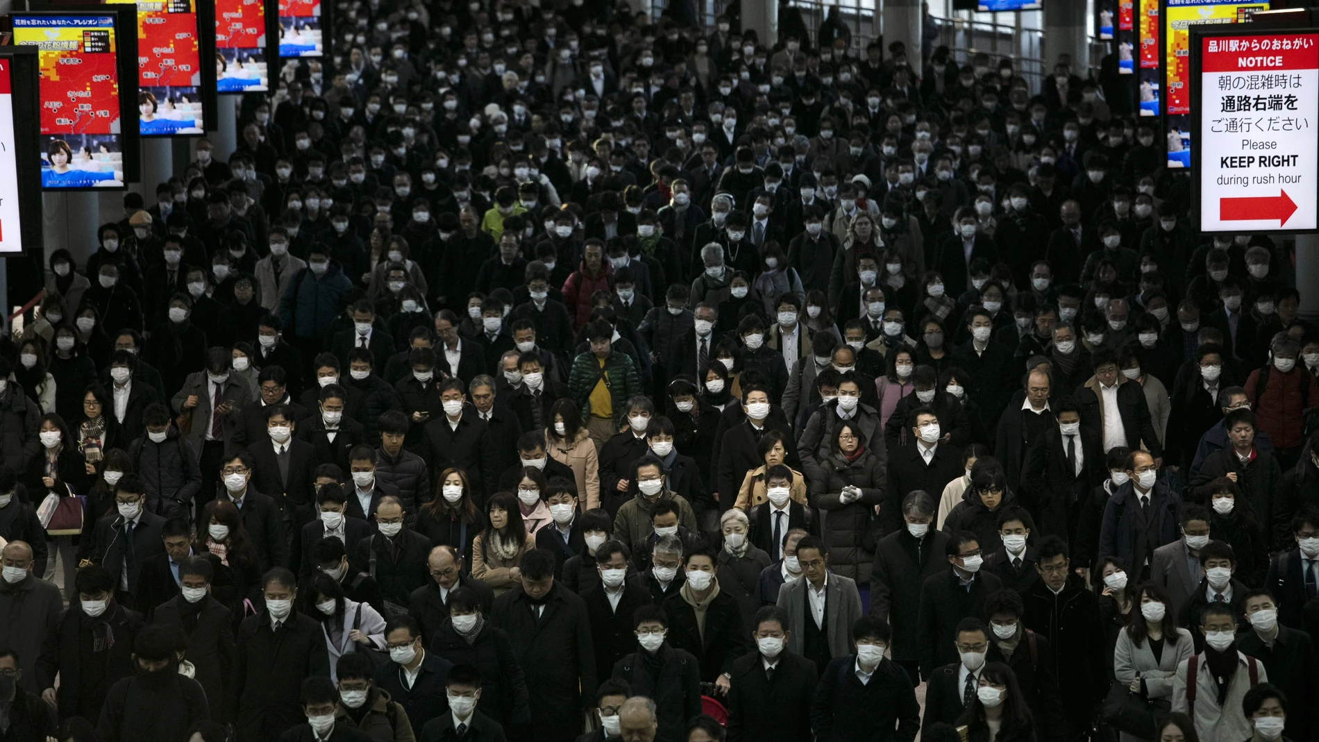 Una gran multitud de gente con mascarilas camina por la estación de Shinagawa en Tokio