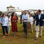 El consejero de Ssostenibilidad, Ramón Fernández Pacheco, junto a la directora de Asuntos Corporativos de Heineken, recorren con varias personas los alrededores de la finca Dehesa de Abajo