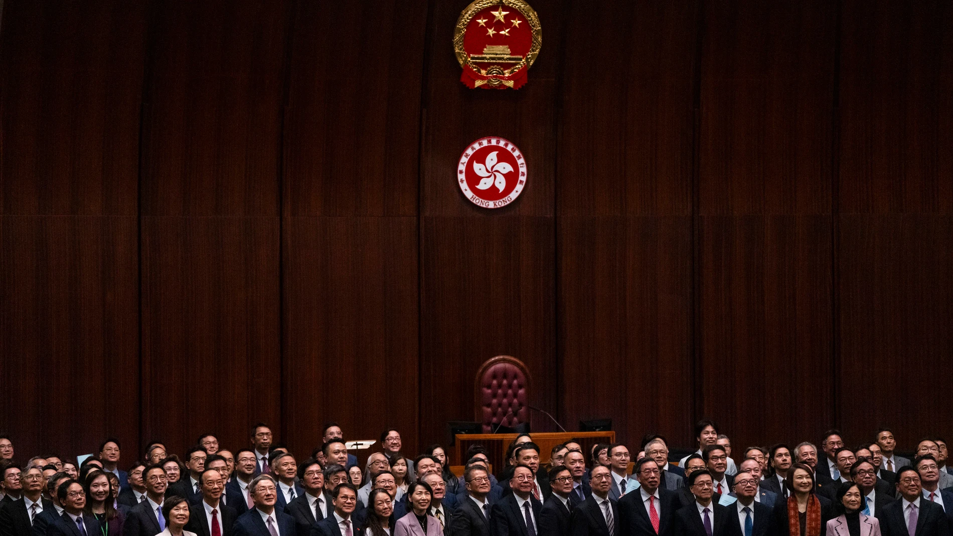 Hong Kong's Chief Executive John Lee Ka-chiu poses for photographs with lawmakers following the passing of the Basic Law Article 23 legislation at the Legislative Council in Hong Kong, Tuesday, March 19, 2024. (AP Photo/Louise Delmotte)