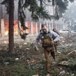 Un militar ucraniano corre en un edificio industrial incendiado en Járkiv