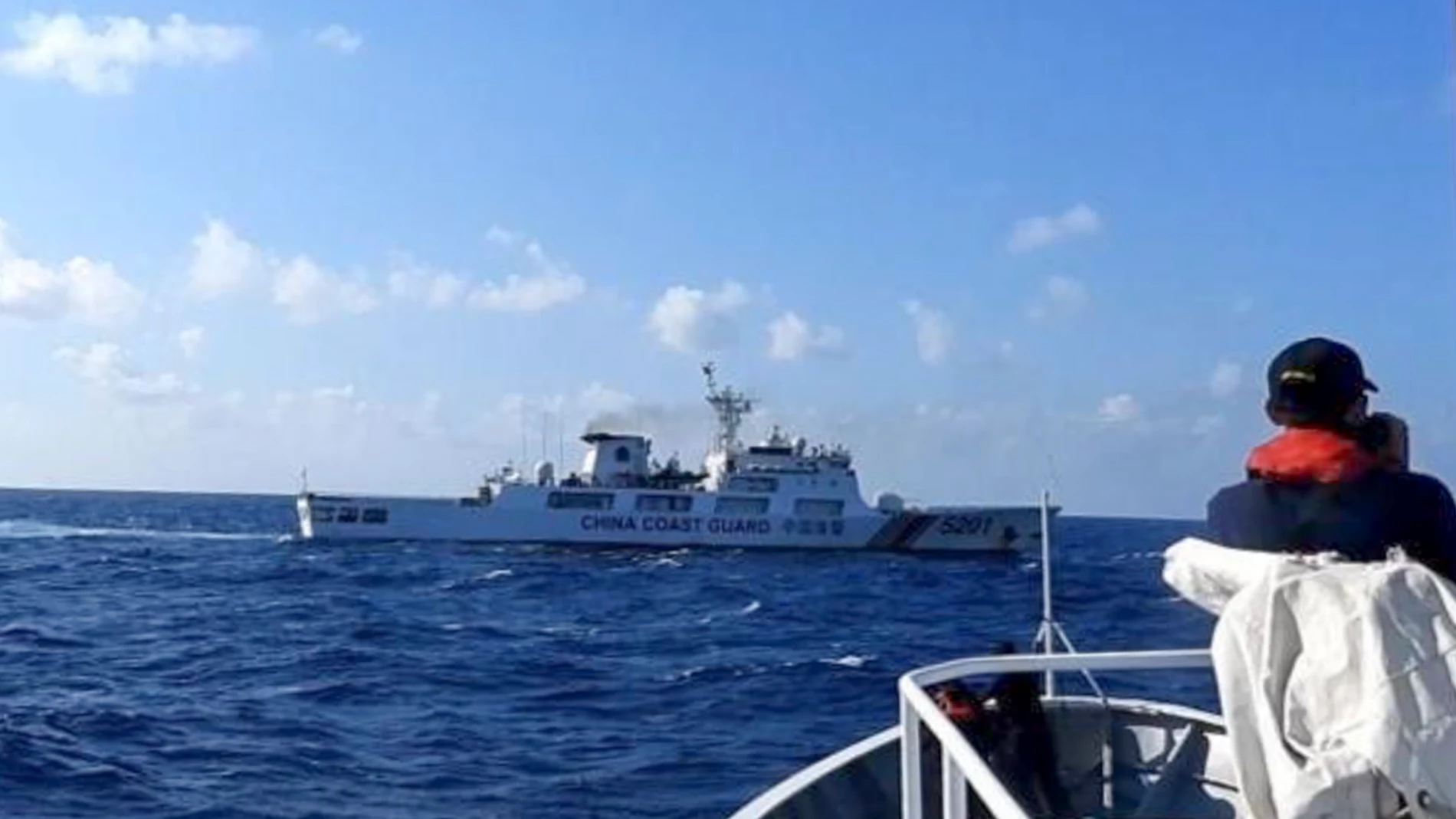 In this photo provided by the Philippine Coast Guard, a Chinese coast guard ship, top, tries to block a Philippine government vessel at the disputed South China Sea on Thursday March 21, 2024. Chinese coast guard ships, backed by a military helicopter, tried to dangerously block but failed to stop two Philippine government vessels carrying scientists from reaching two barren sandbars called Sandy Cay in the disputed South China Sea, Philippine officials said Friday. (Philippine Coast Guard vi...