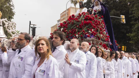 Varios sanitarios portan el trono de traslado de Nuestro Padre Jesús Cautivo y María Santísima Coronada de la Trinidad