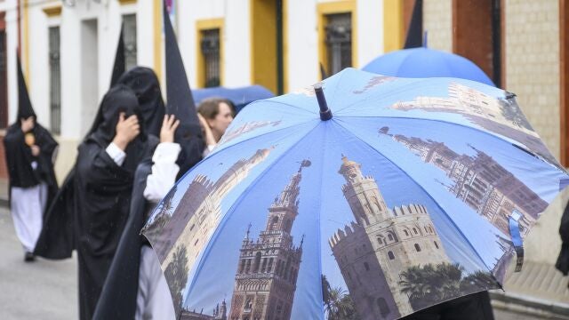 Nazarenos de la hermandad de Santa Genoveva, una de las nueve cofradías que salen en procesión el Lunes Santo en Sevilla, se dirigen a su templo este lunes en el que no procesionarán tras la decisión tomada debido a la lluvia que desde primera hora de la mañana cae en la capital andaluza.