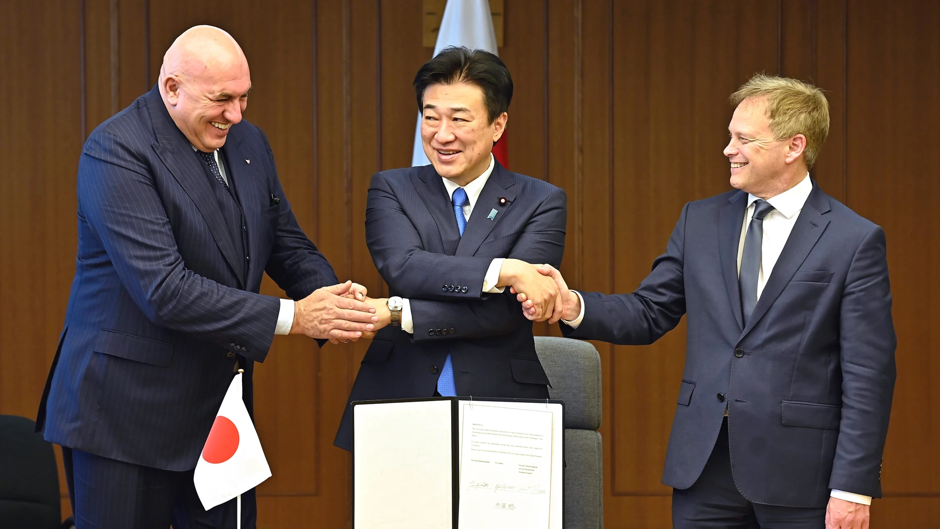 FILE - Britain's Defense Minister Grant Shapps, right, Italy's Defense Minister Guido Crosetto, left, and Japanese Defense Minister Minoru Kihara, center, shake hands after a signing ceremony for the Global Combat Air Programme (GCAP) at the defense ministry, Dec. 14, 2023, in Tokyo, Japan. Japan’s Cabinet on Tuesday, March 26, 2024, approved a plan to sell future next-generation fighter jets that it’s developing with Britain and Italy to other countries, in the latest move away from the coun...