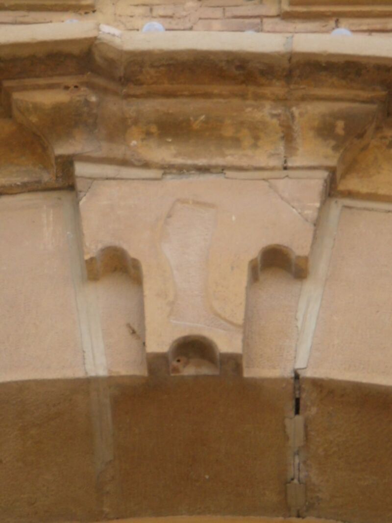 Representación escultórica de la pierna cortada de Miguel Juan Pellicer, en la clave del arco de la portada del Templo del Pilar de Calanda.