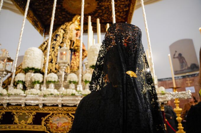 Una mujer vestida de mantilla reza a La Virgen del Mayor Dolor y Traspaso, a 28 de marzo de 2024, en Sevilla