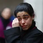 Una joven penitente llora tras no poder salir en Valladolid la procesión del Santísimo Cristo de la Luz por la lluvia