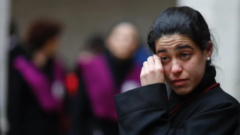 Una joven penitente llora tras no poder salir en Valladolid la procesión del Santísimo Cristo de la Luz por la lluvia