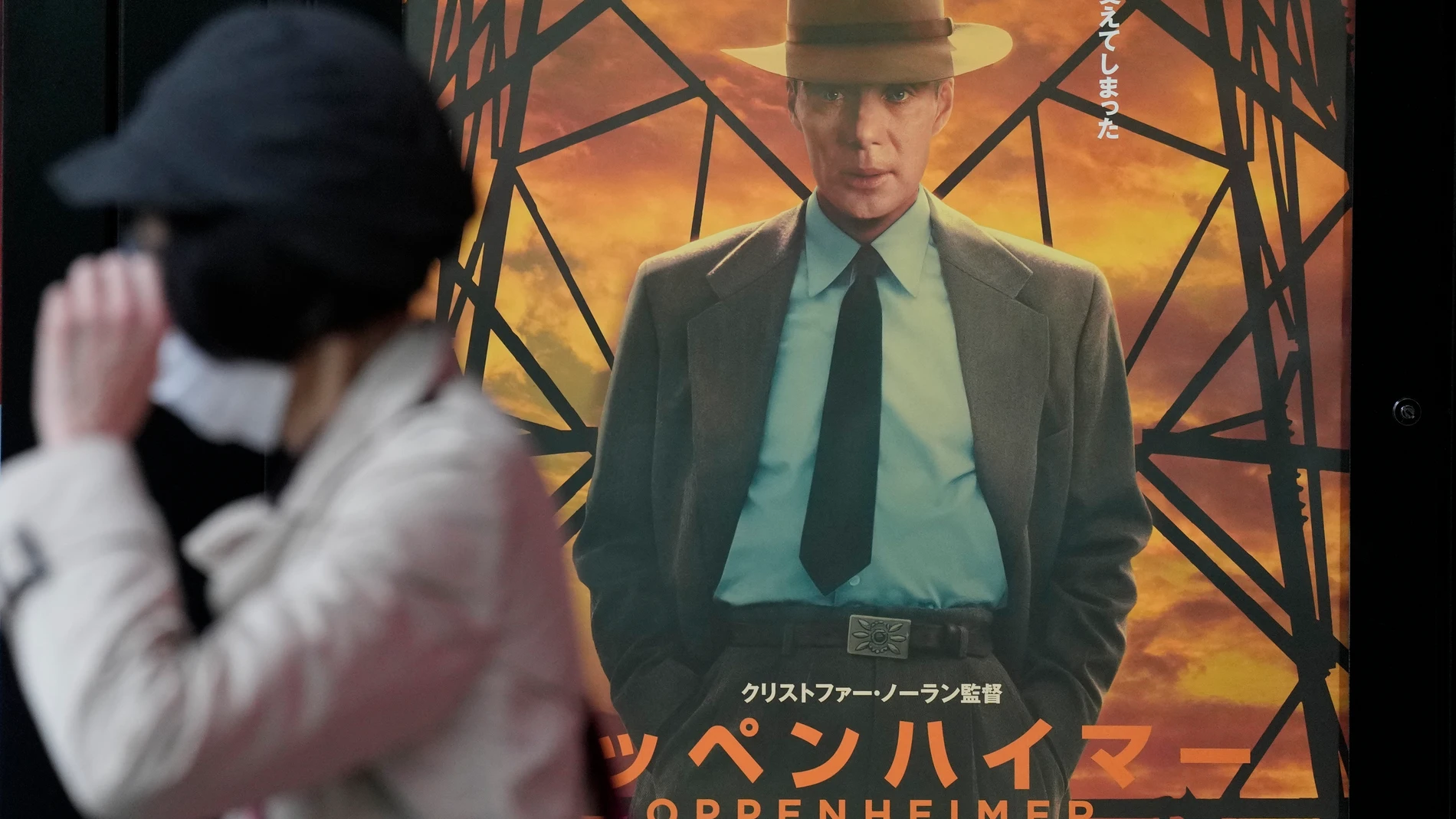 A person walks by a poster to promote the movie "Oppenheimer" Friday, March 29, 2024, in Tokyo. “Oppenheimer” finally premiered Friday in the nation where two cities were obliterated 79 years ago by the nuclear weapons invented by the American scientist who was the subject of the Oscar-winning film. Japanese filmgoers' reactions understandably were mixed and highly emotional. (AP Photo/Eugene Hoshiko)