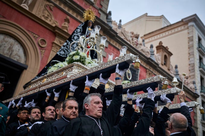 Cofrades y nazarenos durante la procesión de Semana Santa de Nuestra Señora de la Soledad y Desamparo y del Pa