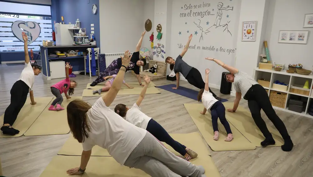 a profesora de yoga Mónica Santamaría imparte una clase a niñas acompañadas de madres y abuela en su academia 'De la Mano de la Infancia'