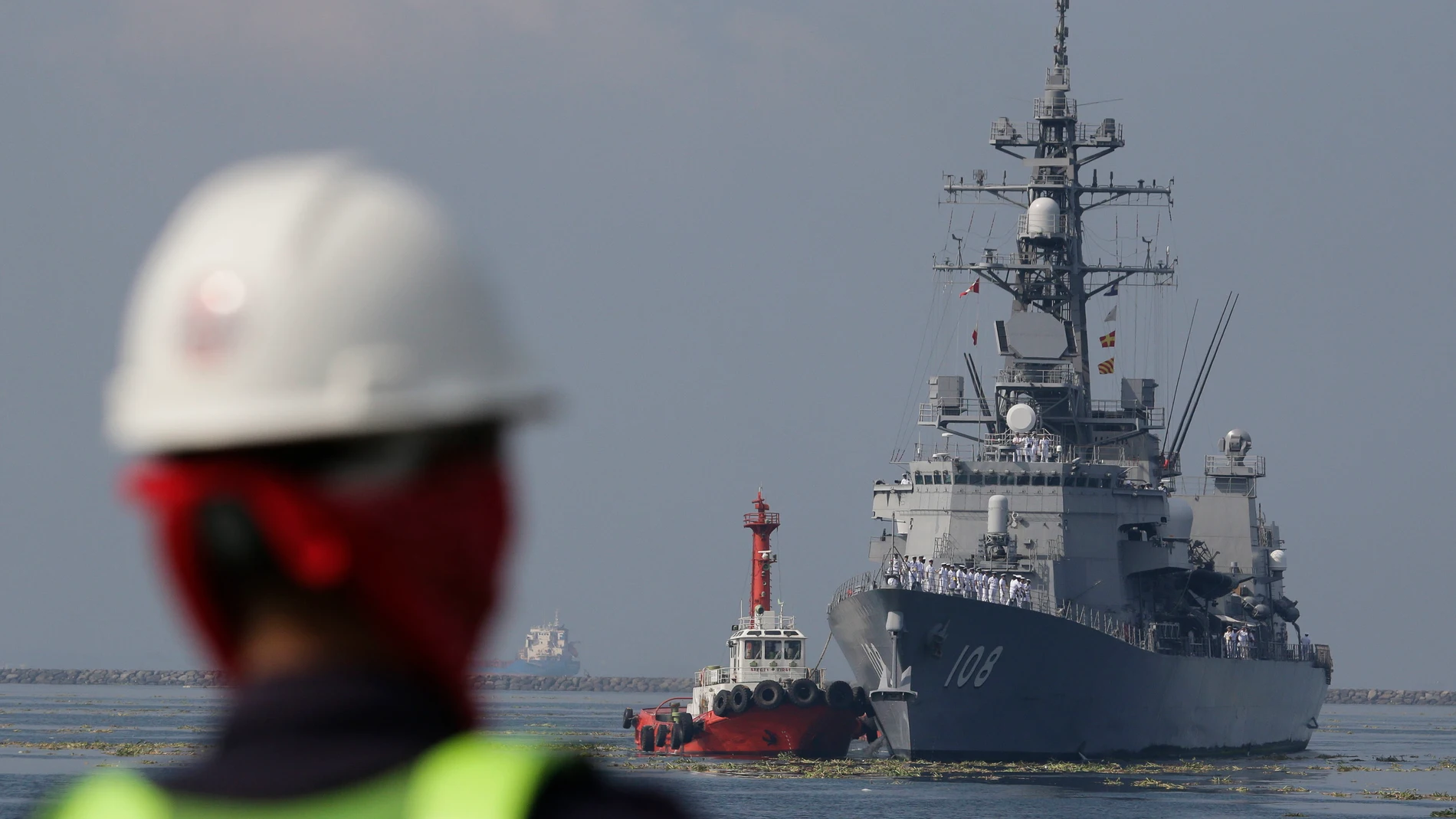 FILE - A Filipino port worker looks as the Japanese Ship Akebono (DD-108), a Murasame-class destroyer of the Japan Maritime Self-Defense Force, prepares to dock for a goodwill visit at Manila's south harbor, Philippines on Sept. 27, 2018. The United States, Japan, Australia and the Philippines will hold their first joint naval exercises, including anti-submarine warfare training, in a show of force Sunday, April 7, 2024 in the South China Sea where Beijing’s aggressive actions to assert its t...