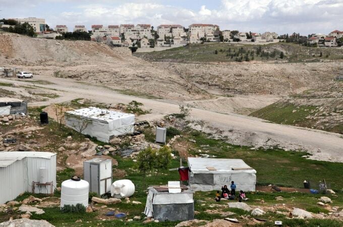 Ma'ale Adumim, back ground, an urban Israeli settlement , is near village, front, in the West Bank on March 7, 2024.