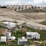 Ma'ale Adumim, back ground, an urban Israeli settlement , is near village, front, in the West Bank on March 7, 2024.