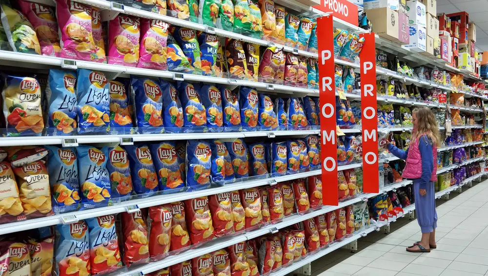 Pasillo con una variedad de productos snacks envasados en un hipermercado Carrefour.