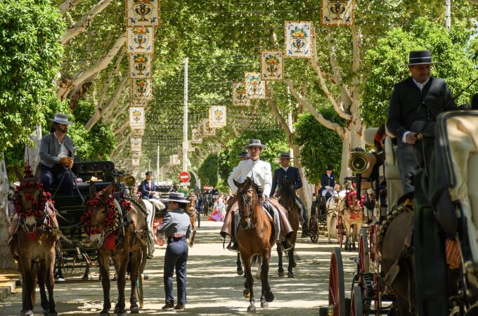 Paseo de caballos en el Real de la Feria en una calurosa jornada de domingo