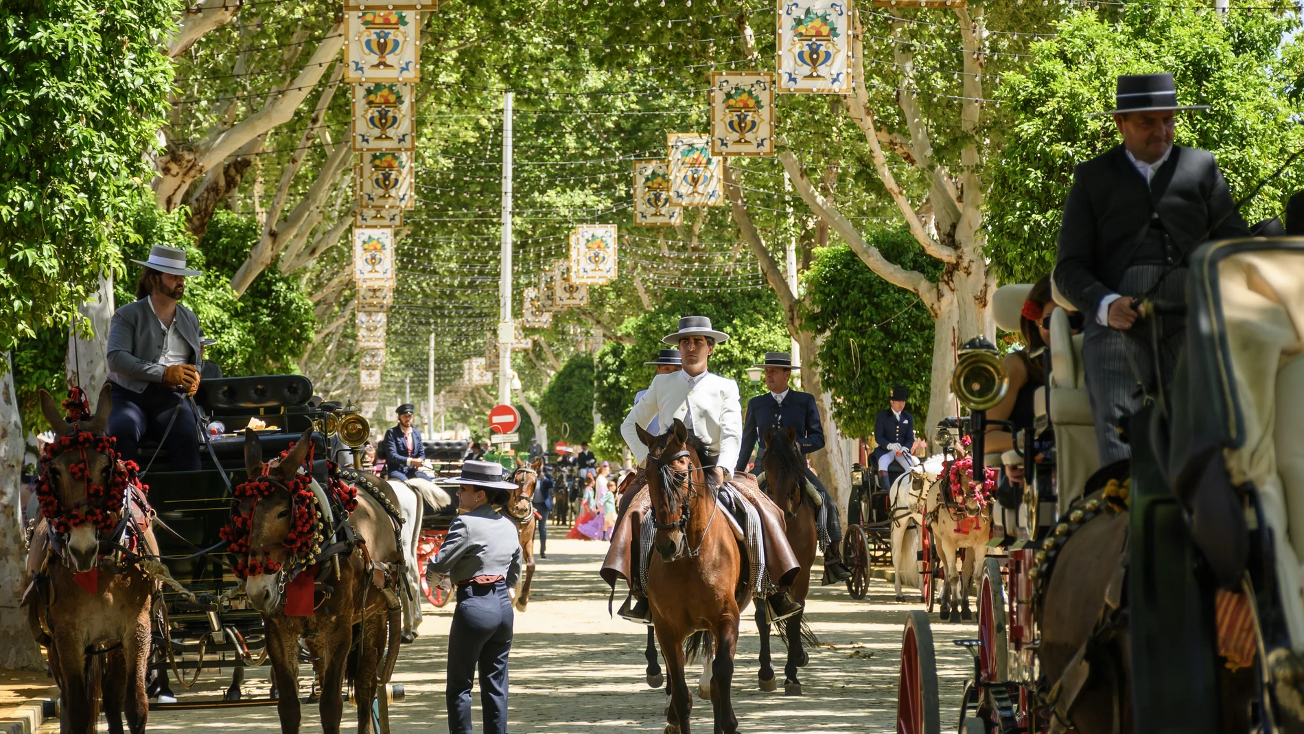 Paseo de caballos en el Real de la Feria en una calurosa jornada de domingo