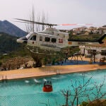 Un helicóptero de los Servicios de Emergencia carga agua en una piscina durante los trabajos de extinción del incendio forestal de Tárbena