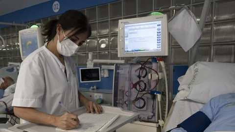 Una sanitaria del Hospital Clínic de Barcelona trabaja tomando notas a mano después de un ciberataque "complejo" sufrido, perpetrado desde fuera de España.