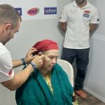 Un técnico implanta un audífono en el oído de una paciente