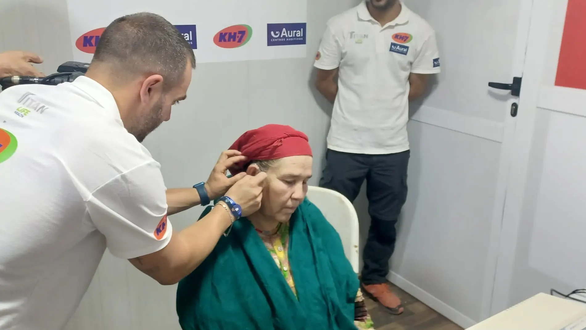 Un técnico implanta un audífono en el oído de una paciente