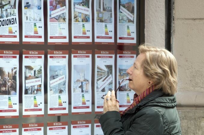 Una persona observa la oferta de pisos en alquiler de una oficina inmobiliaria de Barcelona.