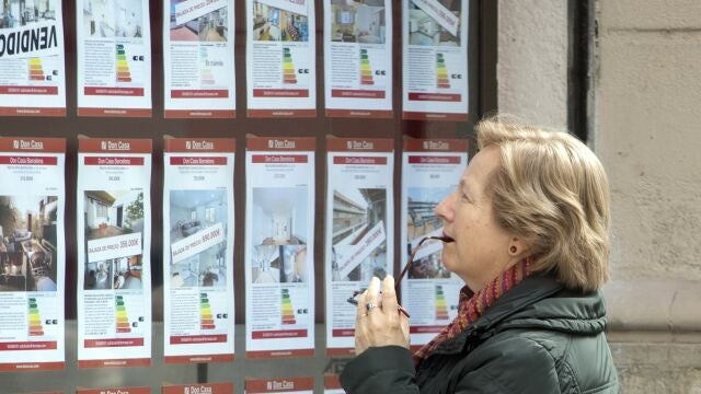Una persona observa la oferta de pisos en alquiler de una oficina inmobiliaria de Barcelona.