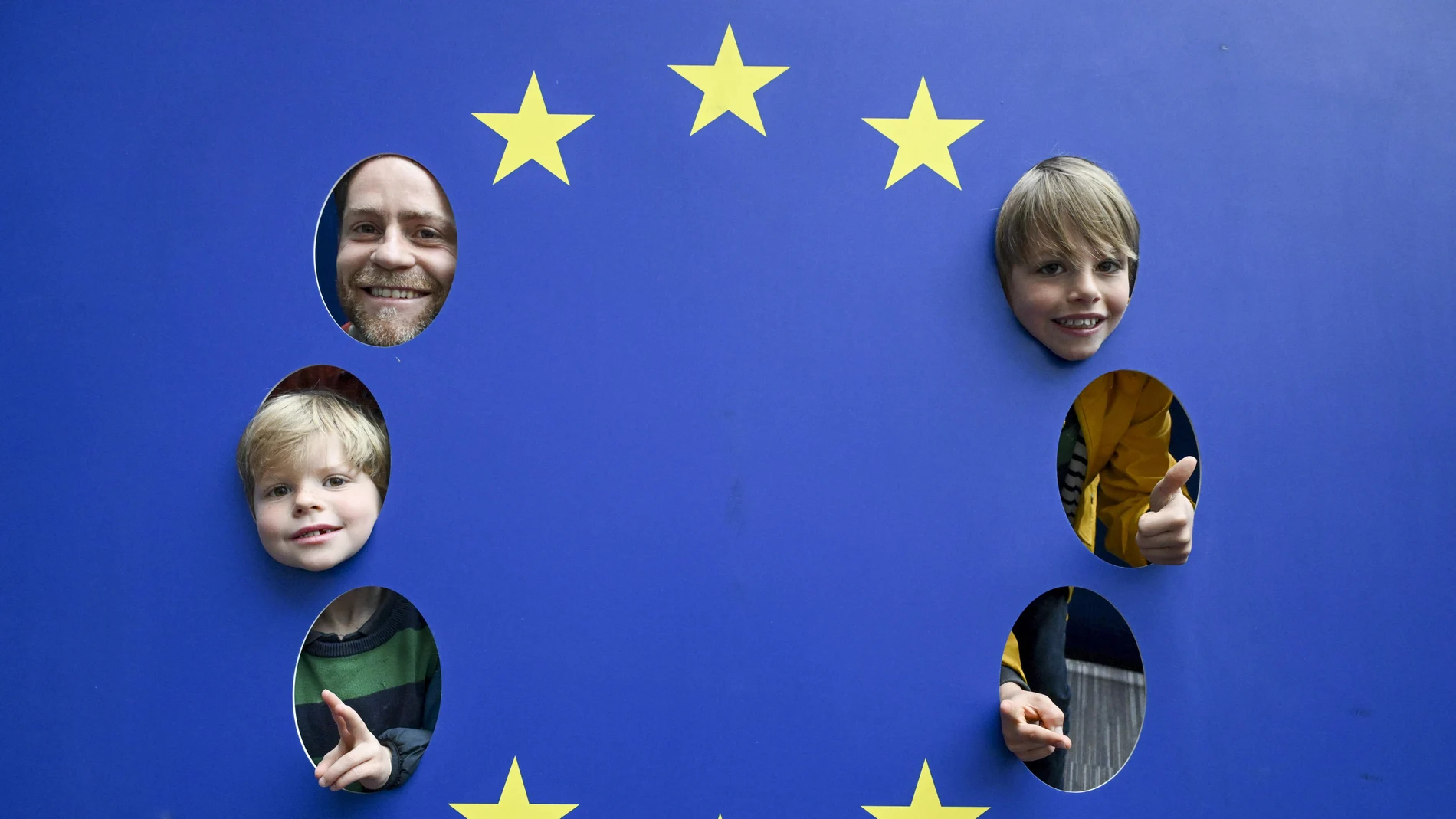 Visitors pose for a picture with EU flag during the open days of European institutions on 'Europe Day' in Brussels, Belgium.